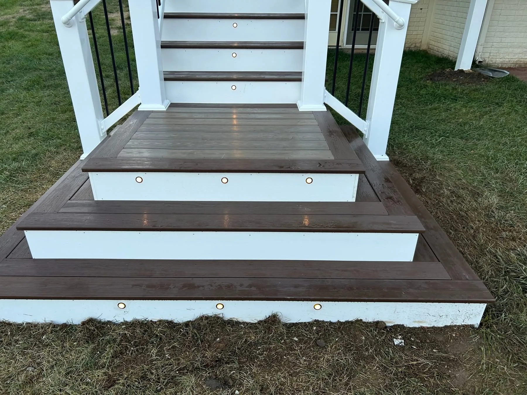 Dark brown composite steps with white risers, inset lights and white railing